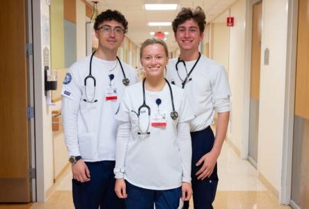 澳门金沙护理系的学生在医院里摆姿势拍照
